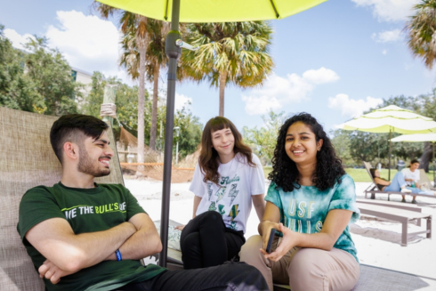 Three students sitting on USF's beach on the Tampa campus, linking out to Why USF webpage.