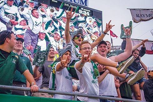 A group of USF students cheering in the stands at a USF football game at Raymond James Stadium in Tampa, FL.